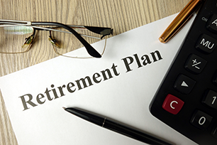 white poster  board with words for retirement plan with calculatot